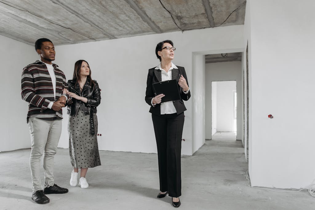 A real estate agent shows an unfinished apartment to prospective buyers.