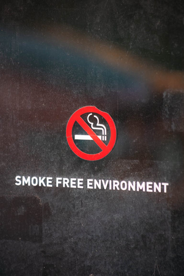 Close-up of no smoking sign indicating a smoke-free environment on a reflective surface.